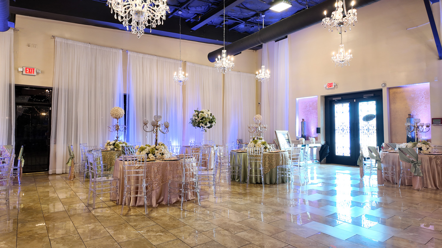 Spacious event hall with modern candle lighting and refined table arrangements designed by Alegria Gardens in Houston.