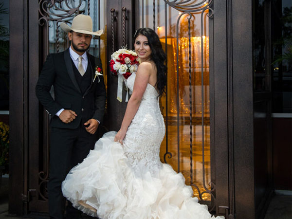 Texan bride and groom taking a picture outside private wedding reception venue - Alegria Gardens, Houston, TX
