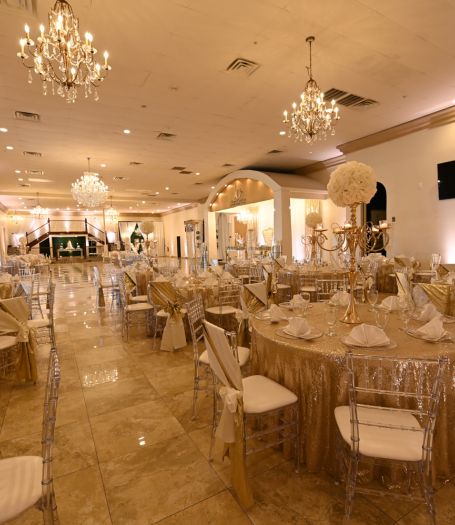 Elegant wedding ceremony setup at Alegria Gardens Houston event hall featuring white chairs and a floral archway.