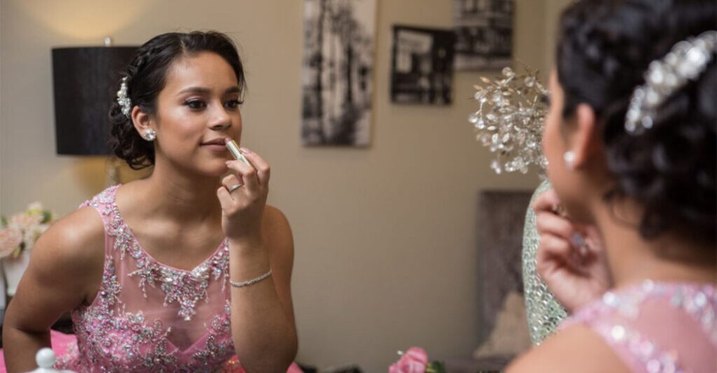 girl putting on makeup during her Quinceañera